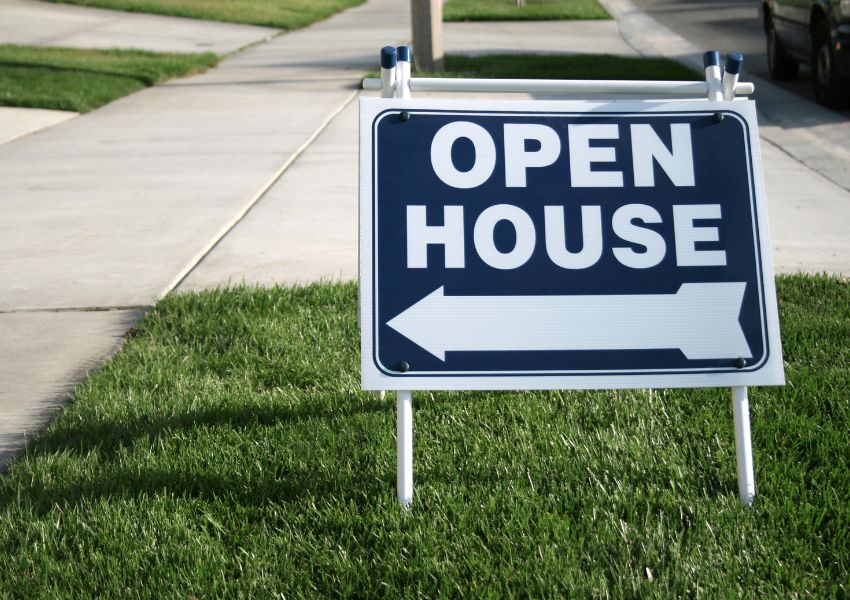 An outdoor open house sign with an arrow pointing to the front door